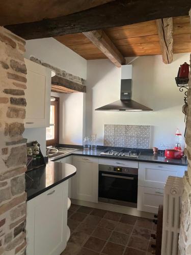 a kitchen with white cabinets and a stove top oven at Il Convento di Roberta in Civitanova del Sannio
