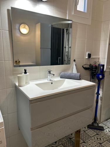 a bathroom with a white sink and a mirror at Le Simplet in Perpignan