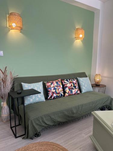 a living room with a green couch with pillows at Le Simplet in Perpignan