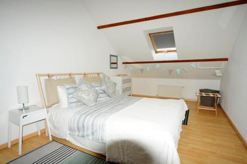 a bedroom with a large white bed in a room at La Maison Rose in Mhère