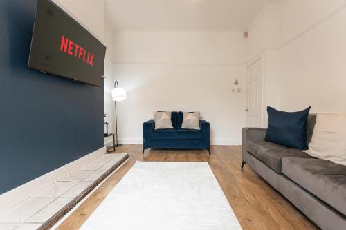 a living room with a couch and a blue chair at Gordan Villas in Leigh