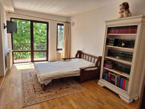 a bedroom with a bed and a book shelf with books at Paradisul de la țara in Moara Vlăsiei