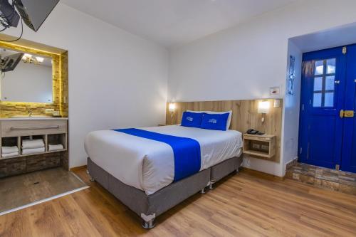 a bedroom with a large bed and a mirror at Estancia San Pedro Hotel in Cusco