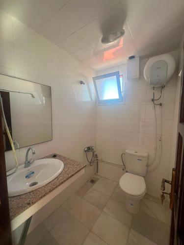 a bathroom with a sink and a toilet and a mirror at Residence Jamal Only Family in Martil