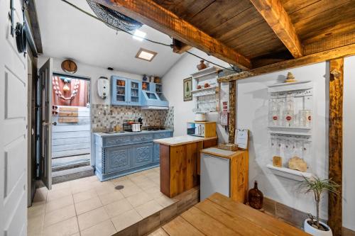 a kitchen with blue cabinets and a refrigerator at The Caravel Apúlia in Apúlia