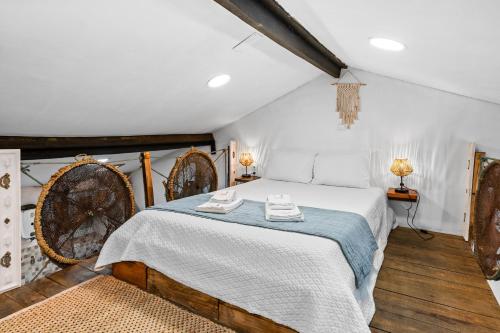 a bedroom with a bed with a blue blanket at The Caravel Apúlia in Apúlia