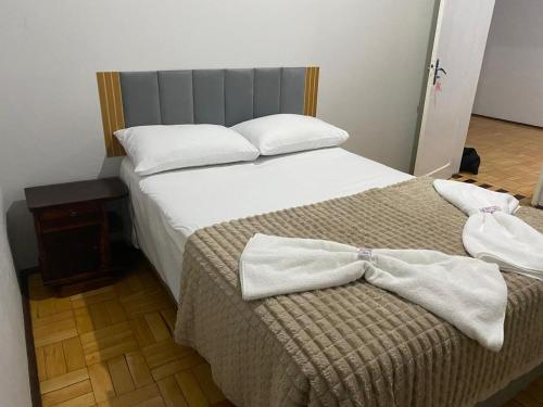 a bedroom with a bed with two towels on it at Hotel Linassi in Cruz Alta