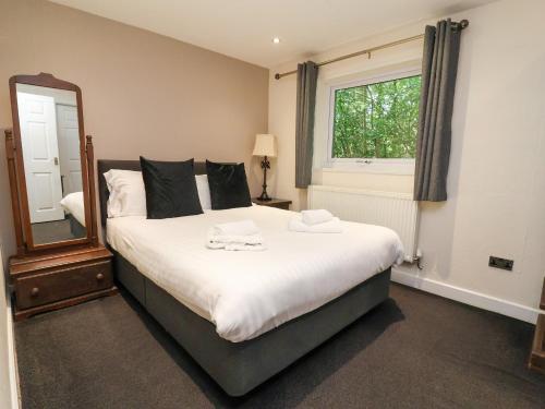 a bedroom with a large bed and a mirror at The Roe in St Asaph
