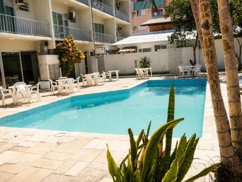 a swimming pool in a hotel with chairs and a palm tree at HANNA Marina's Palace Hotel in Florianópolis