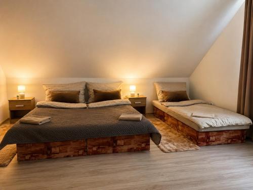 a bedroom with two beds and two lamps on tables at Lesný Dvor Retreat in Spišské Bystré