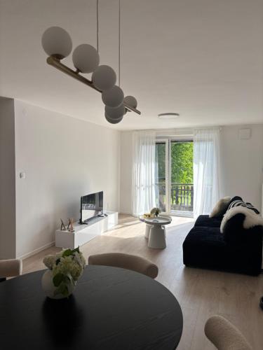 a white living room with a couch and a table at Prenočišče Henrik in Dolenjske Toplice