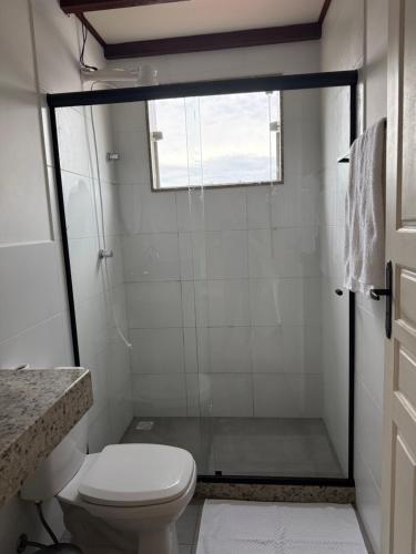 a small bathroom with a toilet and a window at Suíte confortável no centro da cidade in Miguel Pereira