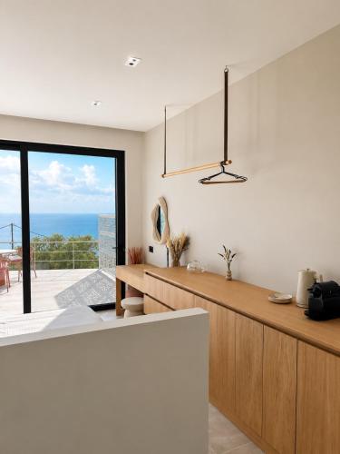 a kitchen with a counter and a view of the ocean at Tellion Villas-Member of My Villas Hospitality in Agios Nikitas