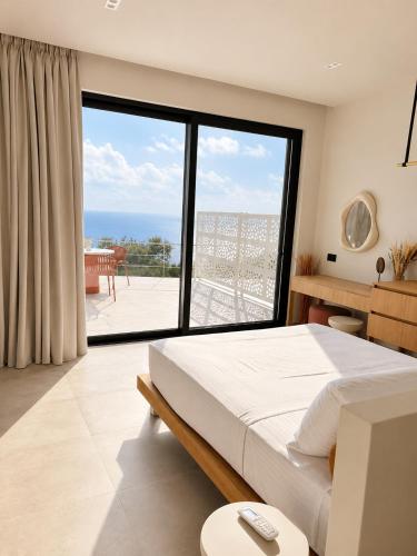 a bedroom with a bed and a large window at Tellion Villas-Member of My Villas Hospitality in Agios Nikitas