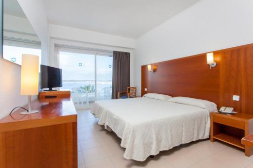 a hotel room with a bed and a television at Hotel Ibiza Playa in Ibiza Town