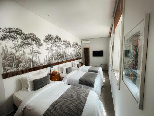 a hotel room with three beds and a tv at Riad Zyo in Rabat