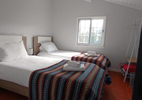 a bedroom with two beds and a window at Villa Visconde in Nordeste