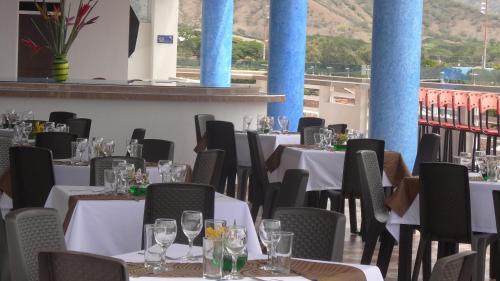 a dining room with tables and chairs with wine glasses at Hotel Oasys Blue in Roldanillo