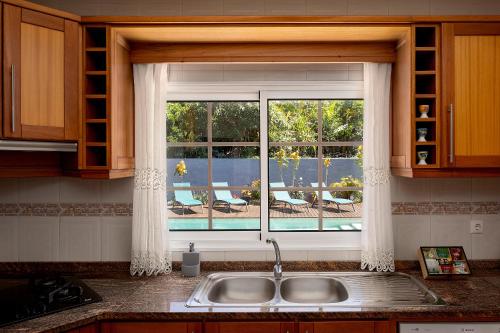 a kitchen sink with a window with a view of a patio at Paradise House Calheta in Calheta