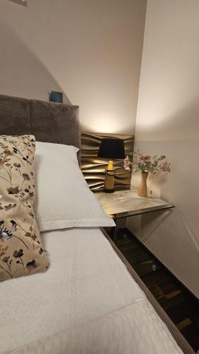 a bedroom with a bed and a table with a lamp at Thea Golden Boutique in Wels