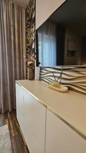 a white dresser with a mirror on top of it at Thea Golden Boutique in Wels