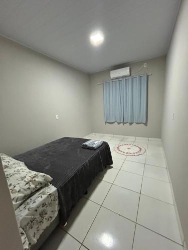 a bedroom with a bed and a tiled floor at Lar doce lar in Barra do Garças