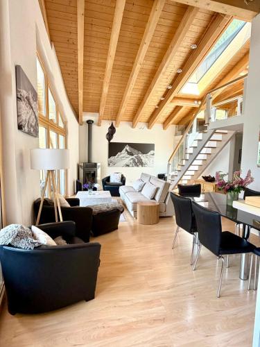 a living room filled with furniture and a wooden ceiling at Victoria's Home - luxurious penthouse in Saas-Fee