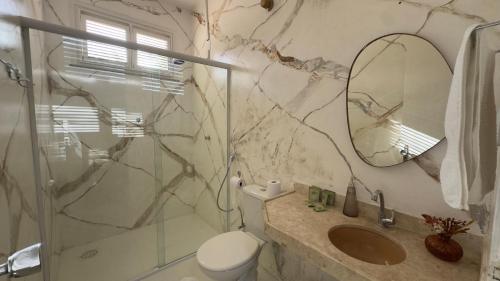 a bathroom with a shower and a toilet and a sink at Pousada Holy Salt Cumbuco in Caucaia