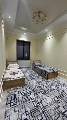 two beds in a large room with a large rug at Lux apartment in Ak-Tyube