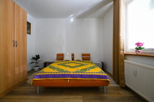 a bedroom with a bed with a colorful blanket on it at Sowa Rigpa apartmán in Gerlachov