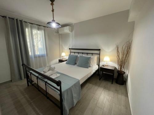 a bedroom with a bed and two tables with lamps at Celeste Syvota in Syvota