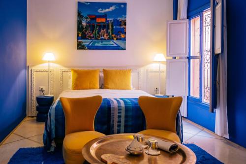a bedroom with a bed and two chairs and a table at Riad Nashira & Spa in Marrakesh