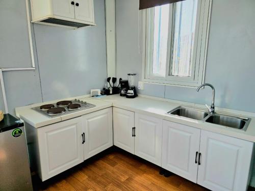 a kitchen with white cabinets and a sink and a window at Abitare lodge Mezcala #2 in Isla de Mezcala
