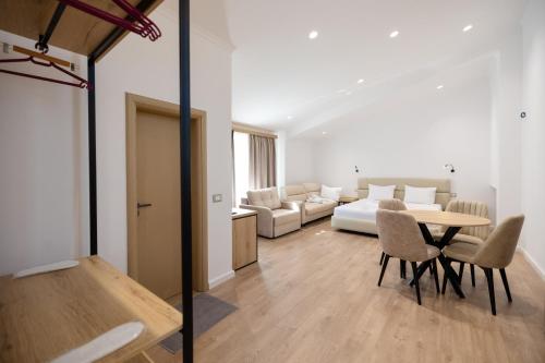 a living room with a bed and a table and chairs at Hotel Petro in Vlorë