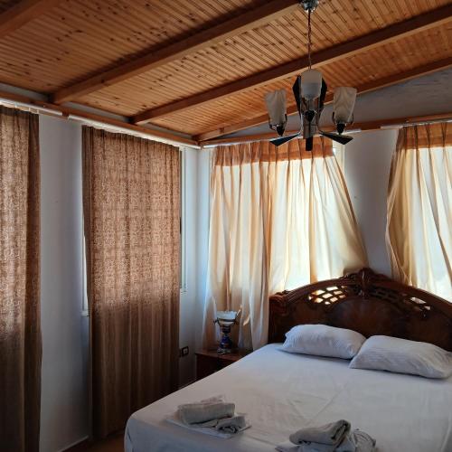 a bedroom with a large bed with a wooden ceiling at Johnny Apartment Berat in Berat