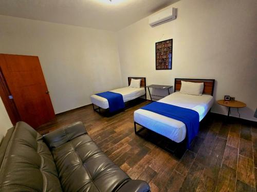 a living room with two beds and a couch at Abitare Mezcala Residencia in Isla de Mezcala
