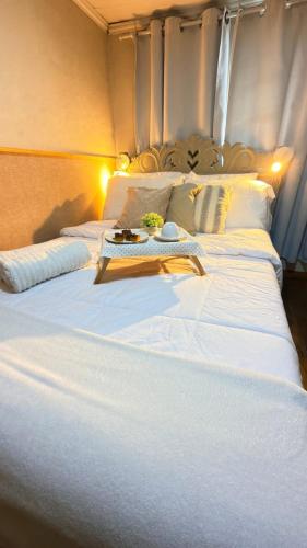 a large white bed with a tray on top of it at Loft Desingn in Volta Redonda