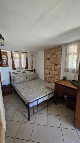 a bedroom with a bed and a wooden table at Lekania House in Káto Nisí