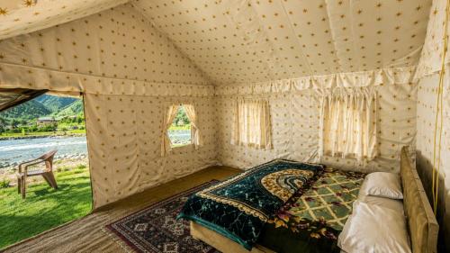 a bedroom with a bed in a tent at GUREZ LUXURY Resort by GRITTI CASTLE in Wāmpor