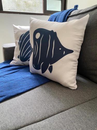 a pillow with a fish on it sitting on a couch at Casa de Praia com Piscina e Espaço Gourmet in Bertioga