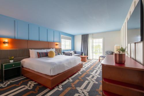 a hotel room with a large bed and a couch at Driftaway Hotel and Pool in Ogunquit
