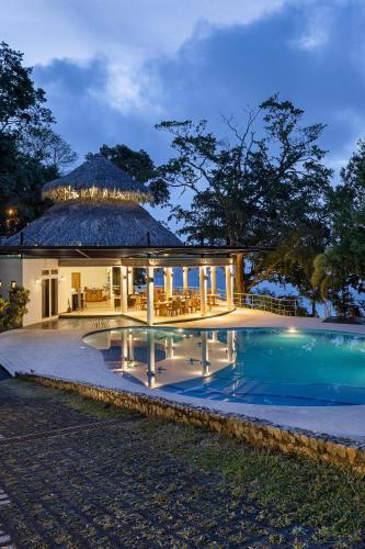 a villa with a swimming pool at night at Bolontiku Boutique Hotel Member of the Cayuga Collection in Flores
