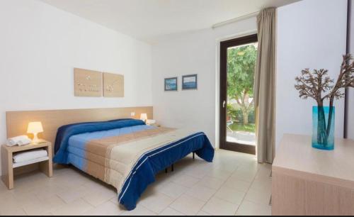 a bedroom with a bed and a large window at Giardino del carrubo in Marina di Ragusa