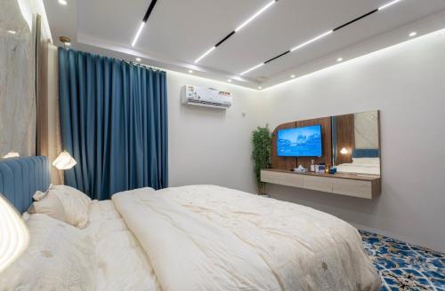 a bedroom with a large bed and a television at جناح اميري in Ash Shishah