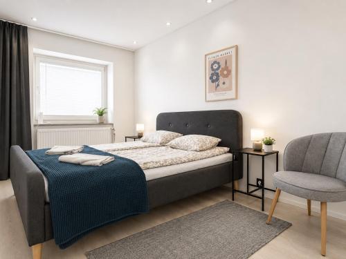 a bedroom with a bed and a chair at Galle's 2 bedroom penthouse in Pori