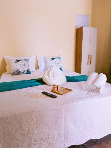 a white bed with a tray and towels on it at Bom Viver Pousada ltda in Viçosa do Ceará