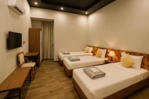 a hotel room with two beds and a television at Global Hanoi Backpackers in Hanoi