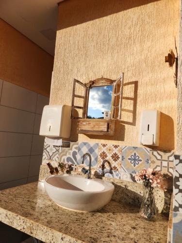 a bathroom with a sink and a mirror at Pousada Cipó Cana in Santana do Riacho