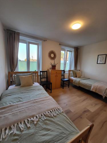 a bedroom with two beds and a desk and windows at Studio in Fürstenfeld