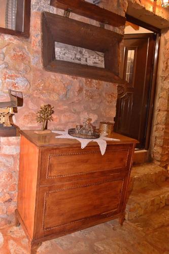 a wooden dresser in a room with a stone wall at VILLA IN THE OLIVE TREES Galaxidi in Galaxidi